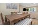 Inviting dining area featuring a wood table, bench seating, and view of the living room at 13414 Alpine Ave, Seminole, FL 33776