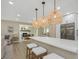 Modern kitchen island with white countertop, wicker bar stools, and stylish pendant lighting at 13414 Alpine Ave, Seminole, FL 33776