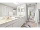 Bathroom featuring a double sink vanity and a mirrored sliding door to the Primary bedroom at 1728 Golfview Dr # 1728, Tarpon Springs, FL 34689