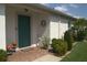 Inviting front entrance with a decorative green door, brick landing, and attractive landscaping at 1746 Ravenridge St, Wesley Chapel, FL 33543