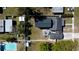 Aerial view displaying the home's layout, fenced yard, patio with furniture, and nearby swimming pool at 210 83Rd N Ave, St Petersburg, FL 33702