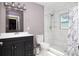 Updated bathroom featuring a tiled shower with window, modern vanity and mirror, and neutral paint at 210 83Rd N Ave, St Petersburg, FL 33702