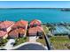 Aerial view of waterfront homes with boat docks, tennis court, and lush landscaping at 230 Sand Key Estates Dr, Clearwater, FL 33767