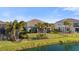 A serene backyard with lush green lawn, mature landscaping, and a calming view of the adjacent lake at 3248 Anchor Bay Trl, Bradenton, FL 34211