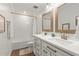 Bright bathroom featuring double vanity with white countertops and bronze fixtures, tub with white tile surround, and wood-look floors at 3248 Anchor Bay Trl, Bradenton, FL 34211
