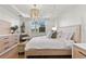 Bright and airy bedroom with elegant chandelier, wood floors, and a stylish sitting bench at 3248 Anchor Bay Trl, Bradenton, FL 34211