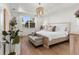 Bright and airy bedroom with elegant chandelier, wood floors, and a stylish sitting bench at 3248 Anchor Bay Trl, Bradenton, FL 34211