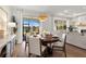 Chic dining area with a round wood table, stylish chandelier, and sliding glass doors leading to the outdoors at 3248 Anchor Bay Trl, Bradenton, FL 34211