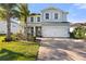 Charming two-story home with a well-manicured lawn, complemented by vibrant tropical landscaping and a spacious driveway at 3248 Anchor Bay Trl, Bradenton, FL 34211