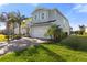 Charming two-story home with a well-manicured lawn, lush palm trees, and a paved driveway leading to a two-car garage at 3248 Anchor Bay Trl, Bradenton, FL 34211