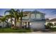 Charming two-story home with a two-car garage, lush lawn and decorative palm trees at 3248 Anchor Bay Trl, Bradenton, FL 34211