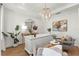 Stylish home office with a large white desk, accent chandelier, and views of adjacent room at 3248 Anchor Bay Trl, Bradenton, FL 34211