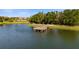 Picturesque view of a neighborhood pond with a wooden dock and lush green surroundings at 3248 Anchor Bay Trl, Bradenton, FL 34211