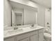 Bright bathroom featuring double sinks, white cabinets, quartz countertops and a large mirror at 3460 Timber Crossing Ave, Brandon, FL 33511