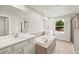 Bright bathroom with double vanities, soaking tub, and glass-enclosed shower at 3460 Timber Crossing Ave, Brandon, FL 33511