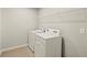 Efficient laundry room featuring a washer, dryer, tile floor and storage shelving at 3460 Timber Crossing Ave, Brandon, FL 33511