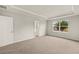 Spacious primary bedroom featuring a tray ceiling, carpet, and en suite bathroom at 3460 Timber Crossing Ave, Brandon, FL 33511