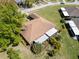 Aerial view of the home with a well-maintained roof, lush landscaping, and a screened-in lanai at 3479 Maclaren Dr, Palm Harbor, FL 34684