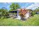 Home's backyard showcasing the screened-in lanai, lush landscaping and verdant lawn at 3479 Maclaren Dr, Palm Harbor, FL 34684