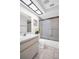 Bright bathroom with a sleek vanity, a skylight and frosted glass enclosed shower at 3479 Maclaren Dr, Palm Harbor, FL 34684