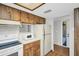 Kitchen featuring laminate floor, appliances, and cabinetry at 3479 Maclaren Dr, Palm Harbor, FL 34684