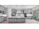Modern kitchen featuring gray cabinets, a large island, stainless steel appliances, and sliding glass doors at 3575 Santa Caterina Blvd, Bradenton, FL 34211