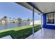A covered back porch featuring tile flooring, green grass, and a tranquil view of the water at 3805 Baden Dr, Holiday, FL 34691