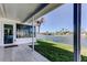 A covered back porch featuring tile flooring, green grass, and a lovely view of the water at 3805 Baden Dr, Holiday, FL 34691