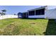 Back exterior of blue home, enclosed patio, and expansive green lawn at 3805 Baden Dr, Holiday, FL 34691