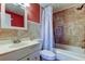 Bathroom featuring a shower-tub combo, a white vanity, and a red accent wall at 3805 Baden Dr, Holiday, FL 34691