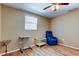 A brightly lit bedroom featuring hard wood flooring, neutral paint, and a comfortable armchair at 3805 Baden Dr, Holiday, FL 34691