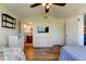Bedroom featuring hardwood floors, a ceiling fan, and a white dresser under a wall-mounted TV at 3805 Baden Dr, Holiday, FL 34691