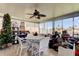 A beautiful sun room with tile floors, a ceiling fan, and a table with four chairs at 3805 Baden Dr, Holiday, FL 34691