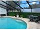 Inviting screened-in pool area with comfortable seating and lush green privacy hedges at 4809 W Juno St, Tampa, FL 33629