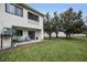 Backyard view featuring a patio seating area, lawn, trees, and privacy fence at 538 Walden Ct, Dunedin, FL 34698