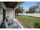 Covered patio seating area with a view of the landscaped backyard and privacy fence at 538 Walden Ct, Dunedin, FL 34698