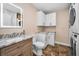 Modern bathroom with marble vanity, white cabinets, and laundry area with new appliances at 538 Walden Ct, Dunedin, FL 34698