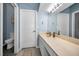 Bright bathroom with a large mirror, beige vanity top, grey flooring and toilet at 538 Walden Ct, Dunedin, FL 34698