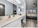Bright bathroom featuring a large vanity, mirror, and grey wood-look flooring at 538 Walden Ct, Dunedin, FL 34698
