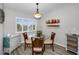 Cozy dining area featuring a round glass table, wood chairs, and a window with plantation shutters at 538 Walden Ct, Dunedin, FL 34698