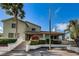 Exterior view of the condo with a staircase leading to a covered porch surrounded by colorful, tropical landscaping at 538 Walden Ct, Dunedin, FL 34698