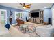 Cozy living room with blue walls, ceiling fan, media center, and elegant decor at 538 Walden Ct, Dunedin, FL 34698