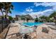 Patio and seating area by the community pool with lounge chairs and tables, all surrounded by manicured landscaping at 538 Walden Ct, Dunedin, FL 34698