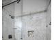 Modern shower stall featuring white marble tile, glass doors and dark fixtures at 538 Walden Ct, Dunedin, FL 34698