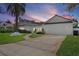 Charming single-story home featuring a well-manicured lawn, a two-car garage, and a lovely walkway leading to the front door at 5973 Leeland S St, St Petersburg, FL 33715