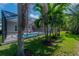 The backyard boasts lush landscaping, a screened-in pool, and two pink Adirondack chairs at 6915 Sea Stone Ct, Apollo Beach, FL 33572