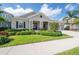 Charming one-story home featuring a manicured lawn, lush landscaping, and a welcoming covered front porch at 6915 Sea Stone Ct, Apollo Beach, FL 33572