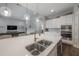 Close-up of a kitchen island with a stainless steel sink and quartz countertops at 6915 Sea Stone Ct, Apollo Beach, FL 33572