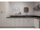 Laundry room features white cabinets, black countertops, sink, and decorative laundry-themed decor at 6915 Sea Stone Ct, Apollo Beach, FL 33572
