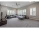 Comfortable living room offers a large sectional couch, carpet flooring and many windows with shutters at 6915 Sea Stone Ct, Apollo Beach, FL 33572